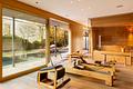 Architekten-Villa mit hochklassiger Ästhetik, Spa-Bereich und Pool in einzigartiger Lage - Zweites Wohnzimmer vor dem Pool als Fitnessbereich mit Sauna und Kamin