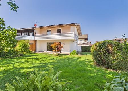 Grünes Familienidyll mit Bergblick – sofort bezugsfreie Doppelhaushälfte auf 578 m² Grundstück - Hausansicht mit Garten
