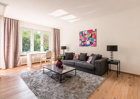 Stil und Charme: Möblierte 2,5-Zimmer-Wohnung mit Balkon in feinster Bogenhauser Lage - Elegantes, luftiges Wohnzimmer