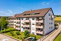 Ruhig gelegene 2-Zimmer-Wohnung mit offener Wohnküche, Balkon & Garage - zum Sommer bezugsfrei - Hausansicht Straße