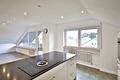 Modern, ruhig und bezugsfrei! Kernsanierte 4-Zimmer-Dachgeschosswohnung mit Garage in Palmbach - Kücheninsel Blick Balkon