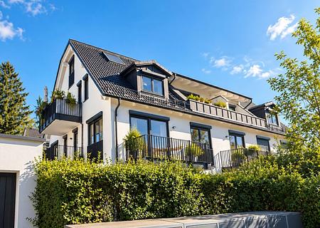 Sonnige 2-Zi.-Wohnung mit zwei Balkonen in ruhiger Lage - Modernes Mehrfamilienhaus unter blauem Himmel